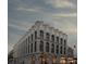 Stunning white corner building with arched windows, set against a dramatic, cloudy sky at 71 Wentworth St # 302, Charleston, SC 29401