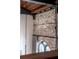 Interior shot of a brick accent wall with exposed ceiling beams and tall windows at 71 Wentworth St # 302, Charleston, SC 29401