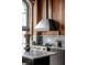 Close up of kitchen details including marble countertops, stainless steel range, and wood paneled backsplash at 71 Wentworth St # 302, Charleston, SC 29401