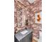Stylish powder room with patterned wallpaper, gold framed mirror, and a black vanity with marble countertop at 71 Wentworth St # 302, Charleston, SC 29401