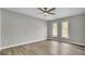 Spacious bedroom features a ceiling fan, wood floors, and natural light from two large windows at 7629 Vanderbrook Pl, North Charleston, SC 29420