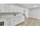 Kitchen with white cabinetry, modern backsplash, and hardwood style floors at 7629 Vanderbrook Pl, North Charleston, SC 29420
