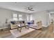 Comfortable living room featuring hardwood floors, stylish sofas, and a ceiling fan, perfect for relaxing or entertaining at 7629 Vanderbrook Pl, North Charleston, SC 29420