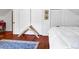 Bedroom with hardwood floors, a blue rug, and a white comforter on the bed, illuminated by natural light at 8262 Fairview Nursery Rd, Hollywood, SC 29449