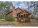 Exterior view of a cozy log cabin with a brick chimney and screened porch at 8262 Fairview Nursery Rd, Hollywood, SC 29449