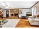 Bright living room featuring hardwood floors, brick fireplace, and ample natural light at 8262 Fairview Nursery Rd, Hollywood, SC 29449