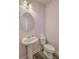 Stylish powder room features a pedestal sink, round mirror, and modern toilet against pink walls at 8475 Athens Way, North Charleston, SC 29420