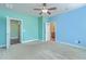 Open bedroom with ceiling fan and neutral carpet leading to a door to the bathroom at 8475 Athens Way, North Charleston, SC 29420