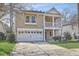 Welcoming two-story house with a charming front porch, green lawn, and convenient attached two-car garage at 8475 Athens Way, North Charleston, SC 29420