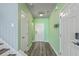 Hallway with neutral paint, modern light fixture, and wood-look flooring leads to the front door at 8475 Athens Way, North Charleston, SC 29420