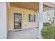 Covered porch featuring a stylish light fixture, neutral siding, and a black-trimmed glass front door at 8475 Athens Way, North Charleston, SC 29420