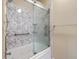 Bathroom shower equipped with glass doors and marble-patterned walls at 8475 Athens Way, North Charleston, SC 29420