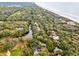 An elevated aerial view of a wooded neighborhood near the coast, featuring a golf course and tranquil ocean waters at 93 Surfscoter Ln, Kiawah Island, SC 29455