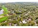Stunning aerial view of homes surrounded by trees, bordering a golf course and a meandering stream at 93 Surfscoter Ln, Kiawah Island, SC 29455