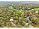 Picturesque aerial view of homes surrounded by lush greenery, adjacent to a golf course and tranquil pond at 93 Surfscoter Ln, Kiawah Island, SC 29455