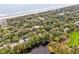 Aerial view showcases homes nestled among lush greenery near the beach and waterway at 93 Surfscoter Ln, Kiawah Island, SC 29455