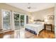 Bright bedroom with hardwood floors, ceiling fan, and sliding glass doors to a private balcony at 93 Surfscoter Ln, Kiawah Island, SC 29455