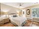 Cozy bedroom with hardwood floors, ceiling fan, a window, and an ensuite bathroom at 93 Surfscoter Ln, Kiawah Island, SC 29455