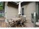 Outdoor deck with a wooden table, chairs and a large umbrella surrounded by wooded area at 93 Surfscoter Ln, Kiawah Island, SC 29455