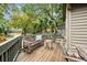 Outdoor deck featuring a bench with pillow, table, and other chairs surrounded by lush greenery at 93 Surfscoter Ln, Kiawah Island, SC 29455