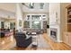 Bright living room with fireplace, hardwood floors, cathedral ceilings, and large windows with backyard views at 93 Surfscoter Ln, Kiawah Island, SC 29455