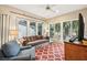 Cozy living room with large windows offering natural light and views of the surrounding greenery at 93 Surfscoter Ln, Kiawah Island, SC 29455