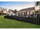 Landscaped backyard showing fence, lawn, tropical plants, and pool house at 108 Whaler Ave, Summerville, SC 29486