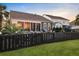 Landscaped backyard showing fence, lawn, tropical plants, and pool house at 108 Whaler Ave, Summerville, SC 29486