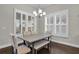 The dining area features large windows, white shutters, stylish table and chairs, and hardwood flooring at 108 Whaler Ave, Summerville, SC 29486