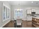 Dining area boasts large windows, white shutters, granite counters, stainless steel appliances, and hardwood floors at 108 Whaler Ave, Summerville, SC 29486