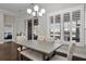 The dining area boasts large windows, white shutters, a modern table set, and hardwood floors at 108 Whaler Ave, Summerville, SC 29486