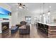 Open concept living room flowing into kitchen and dining area, complete with fireplace, hardwood floors, and ceiling fan at 108 Whaler Ave, Summerville, SC 29486