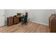 Bedroom with wood-look floors features a desk and chair, vintage cabinet, and white trim and baseboards at 1107 Bellwether Ln, Summerville, SC 29485