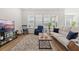 Bright living room with a cozy rug, a comfortable sofa, and large windows offering ample natural light at 1107 Bellwether Ln, Summerville, SC 29485