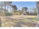 The backyard features a lawn area bordered by trees and a wooden fence at 112 Avonshire Dr, Summerville, SC 29483