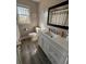 Bright bathroom with a white vanity, framed mirror, wood-look flooring and natural light through the window at 122 Mellard Dr, Goose Creek, SC 29445