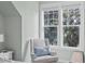 Bright bedroom corner features a comfortable armchair and a window with a lush tree view at 130 River Landing Dr # 4209, Charleston, SC 29492