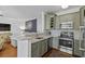 Well-appointed kitchen with stainless steel appliances, granite countertops, tile backsplash, and green cabinetry at 130 River Landing Dr # 4209, Charleston, SC 29492