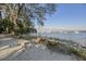 Scenic waterfront view featuring a sandy beach, a wooden bench, and a bridge in the distance, perfect for coastal living at 130 River Landing Dr # 4209, Charleston, SC 29492