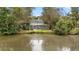 Beautiful backyard featuring an enclosed porch surrounded by lush trees and a serene pond view at 132 Lipman St, Summerville, SC 29483