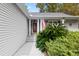 Close-up of a charming home's entrance with a dark front door, patriotic American flag and beautiful landscaping at 132 Lipman St, Summerville, SC 29483
