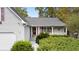 A welcoming front porch with a burgundy door, American flag, and lush greenery at 132 Lipman St, Summerville, SC 29483