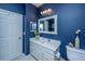 A vanity against a dark blue wall, framed mirror, white sink, and decorative accents create this bathroom's charm at 1581 Cambridge Lakes Dr, Mount Pleasant, SC 29464