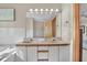 Bathroom featuring double sinks, a large mirror with Hollywood lights and a peek to the bedroom at 1615 E Ashley Ave, Folly Beach, SC 29439