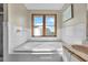 A sunny bathroom featuring a large soaking tub beneath a window with a view at 1615 E Ashley Ave, Folly Beach, SC 29439