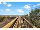Wooden walkway leads to a beautiful sandy beach with ocean views and clear blue skies above at 1615 E Ashley Ave, Folly Beach, SC 29439
