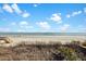A beach view with a wooden walkway leading to the shore, framed by lush greenery at 1615 E Ashley Ave, Folly Beach, SC 29439