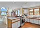 A kitchen with white cabinets and stainless steel appliances, adjacent to the dining room at 1615 E Ashley Ave, Folly Beach, SC 29439