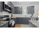 Modern kitchen featuring granite countertops, gray cabinets, stainless steel appliances, and ample natural light at 1738 N N Hwy 52, Bonneau, SC 29431
