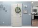 Bright entryway featuring wood floors, light blue walls, and a white door with floral wreath at 202 Tall Grass Ct, Summerville, SC 29483
